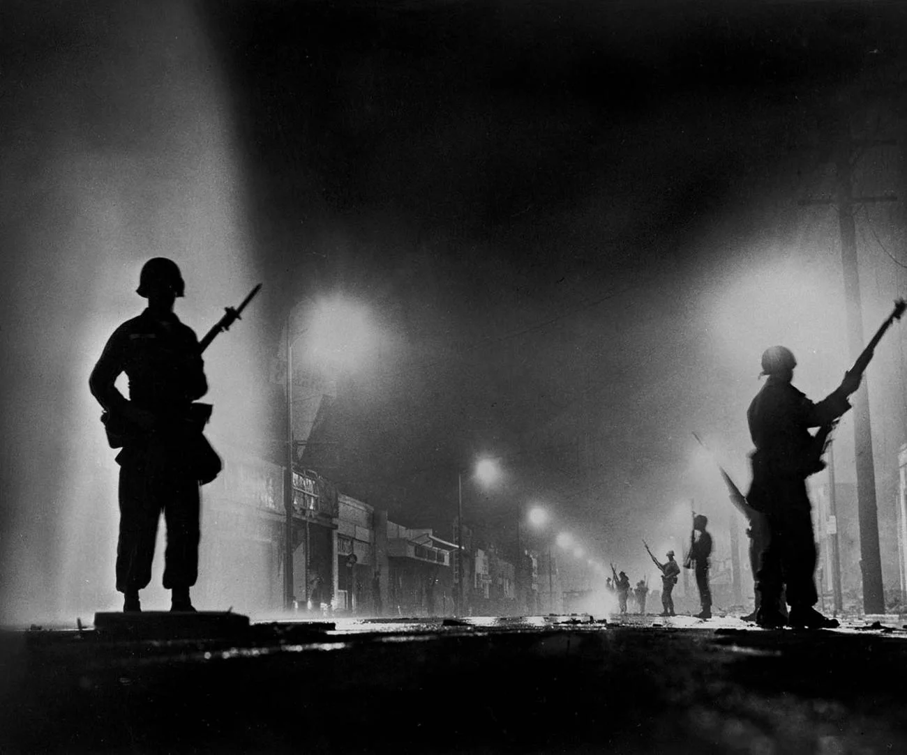 National Guard troops secure a stretch of 103rd Street, dubbed Charcoal Alley, during the Watts riots. This photo was published on the front page of the Aug. 14, 1965, edition of the Los Angeles Times. (John Malmin / Los Angeles Times)