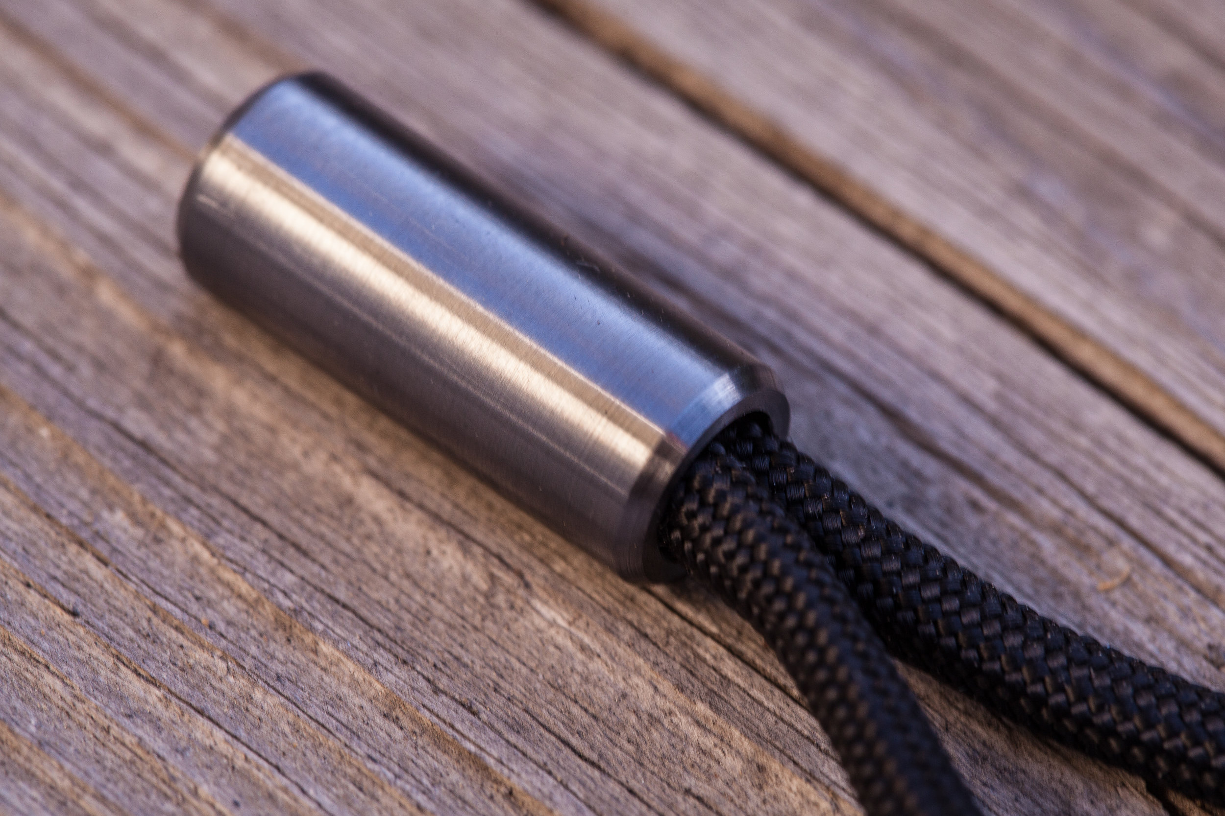 Close up detail showing the surface finish of the titanium Cord Lock with black 550 paracord.
