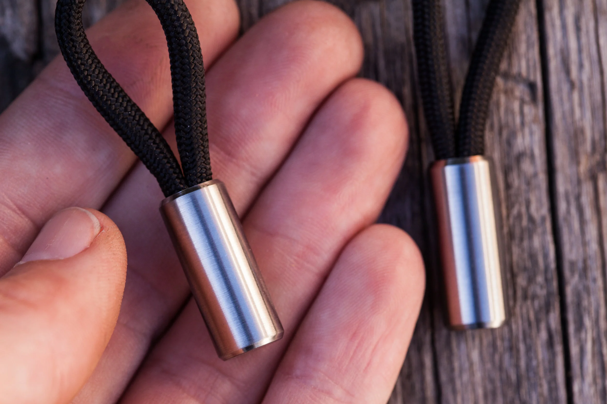 Holding the round titanium version of the Cord Lock in my hand to show its size.