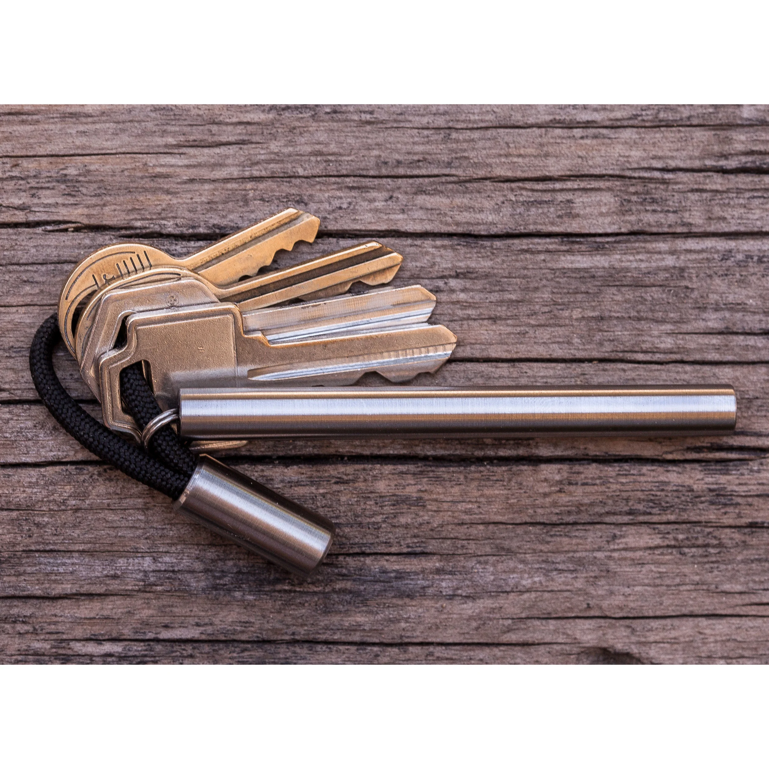 Round titanium Cord Locks with black paracord shown with keys and titanium EDC Ink keychain pen.