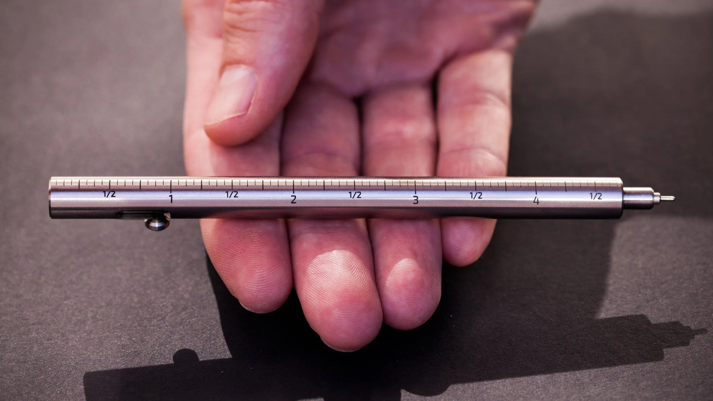 Closeup detail of the PRO version laser engraved measurement scales on the Injector titanium bolt action pen.