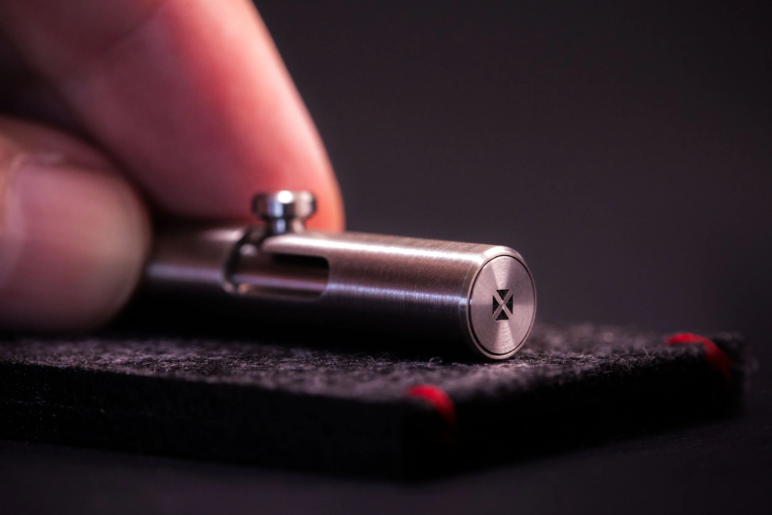 Close up detail of flush end-cap of the Injector bolt action pen showing the laser engraving Blank Forces logo.