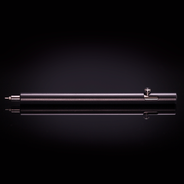 Cerakote Armor Black version of the Injector titanium bolt action pen, shown the table.