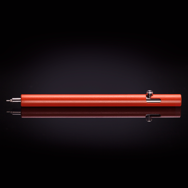 Cerakote Blaze Orange version of the Injector titanium bolt action pen, shown the table.