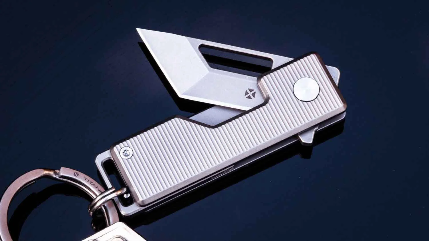 Vector version of the Pocket Tanto EDC Keychain knife with the blade partial open on reflective black table.
