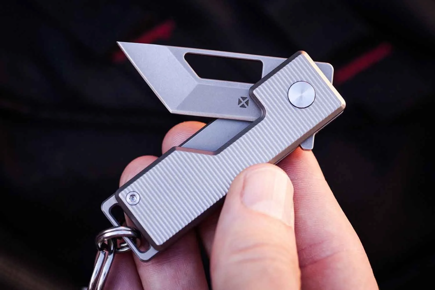 Vector version of the Pocket Tanto EDC Keychain knife with the blade partial open held in hand.