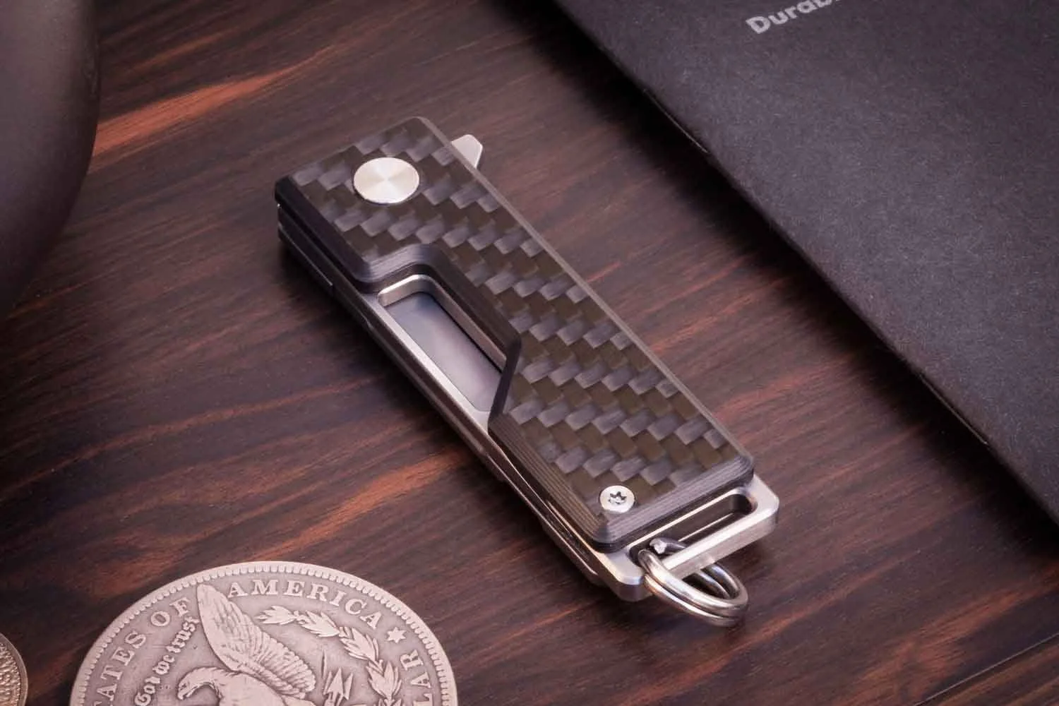 Carbon version of the Pocket Tanto EDC keychain knife with the blade closed.