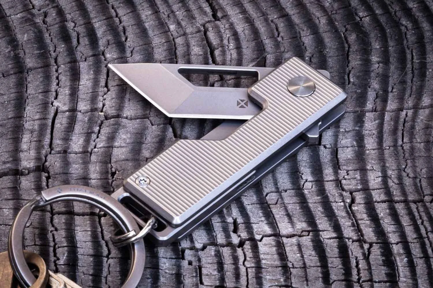 Vector version of the Pocket Tanto EDC Keychain knife with the blade partial open laying on top of wood.