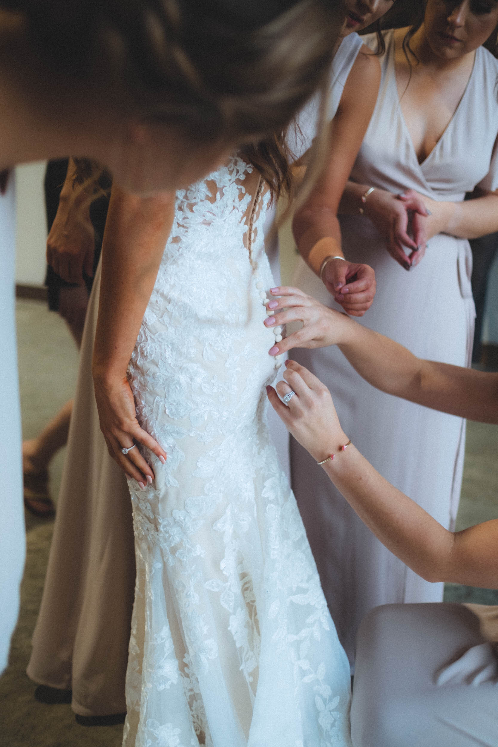 bridesmaids helping with bride's dress