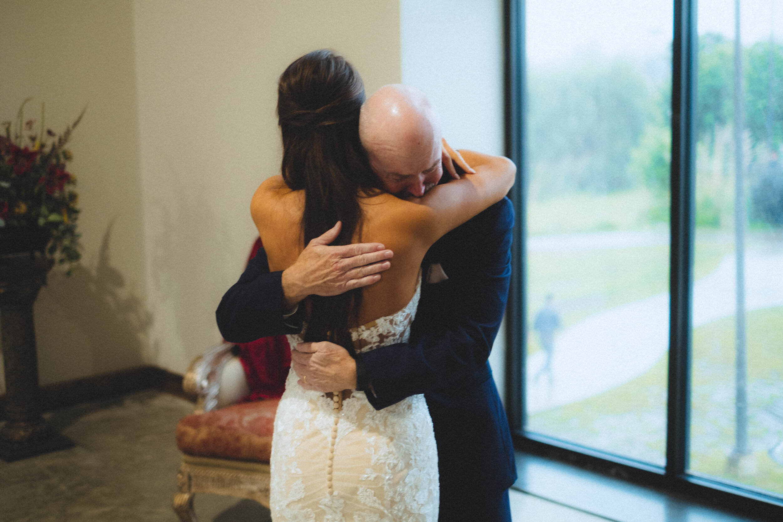 bride hugs dad while he cries