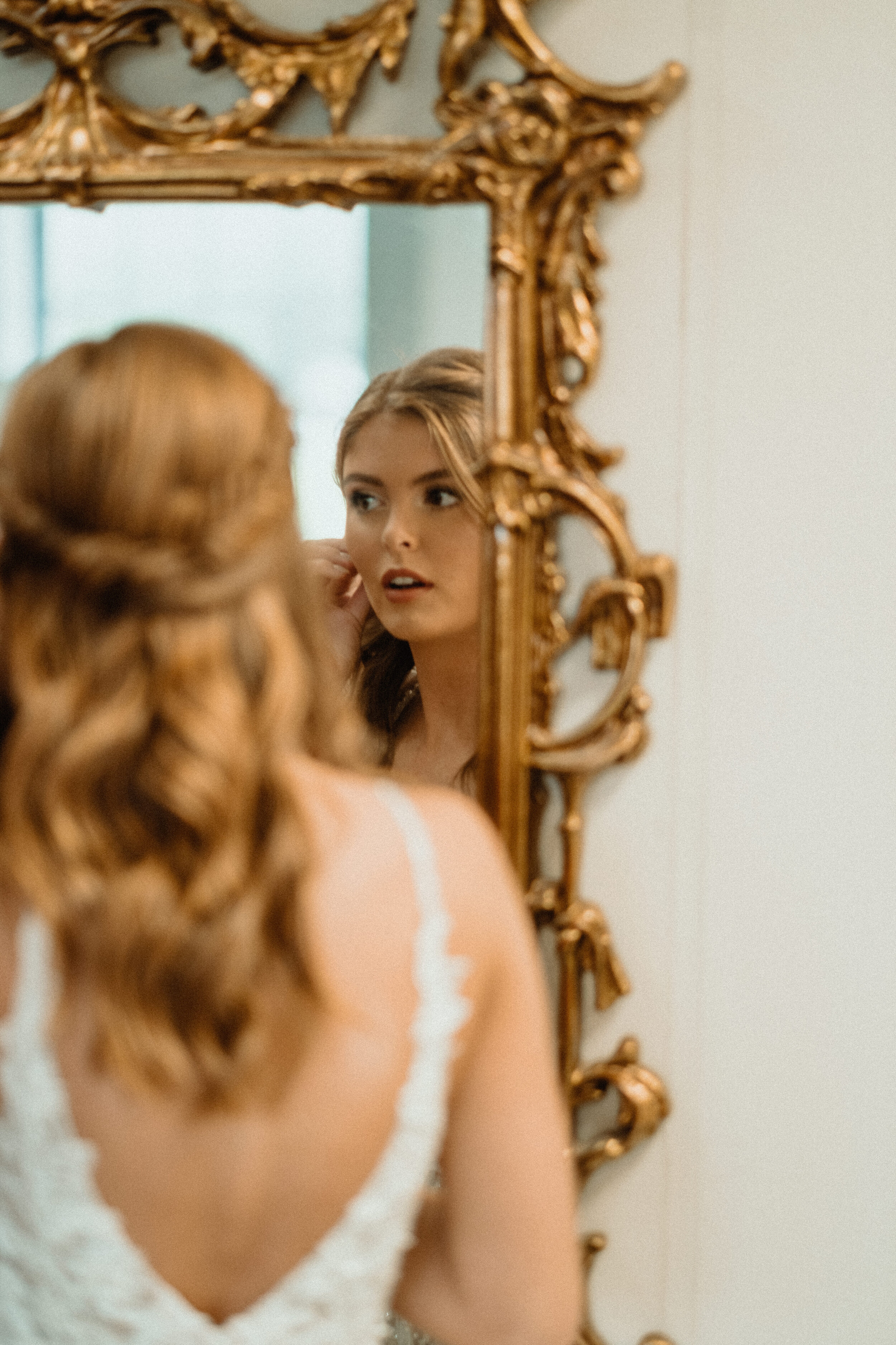 Bride getting ready in mirror Maytag event center