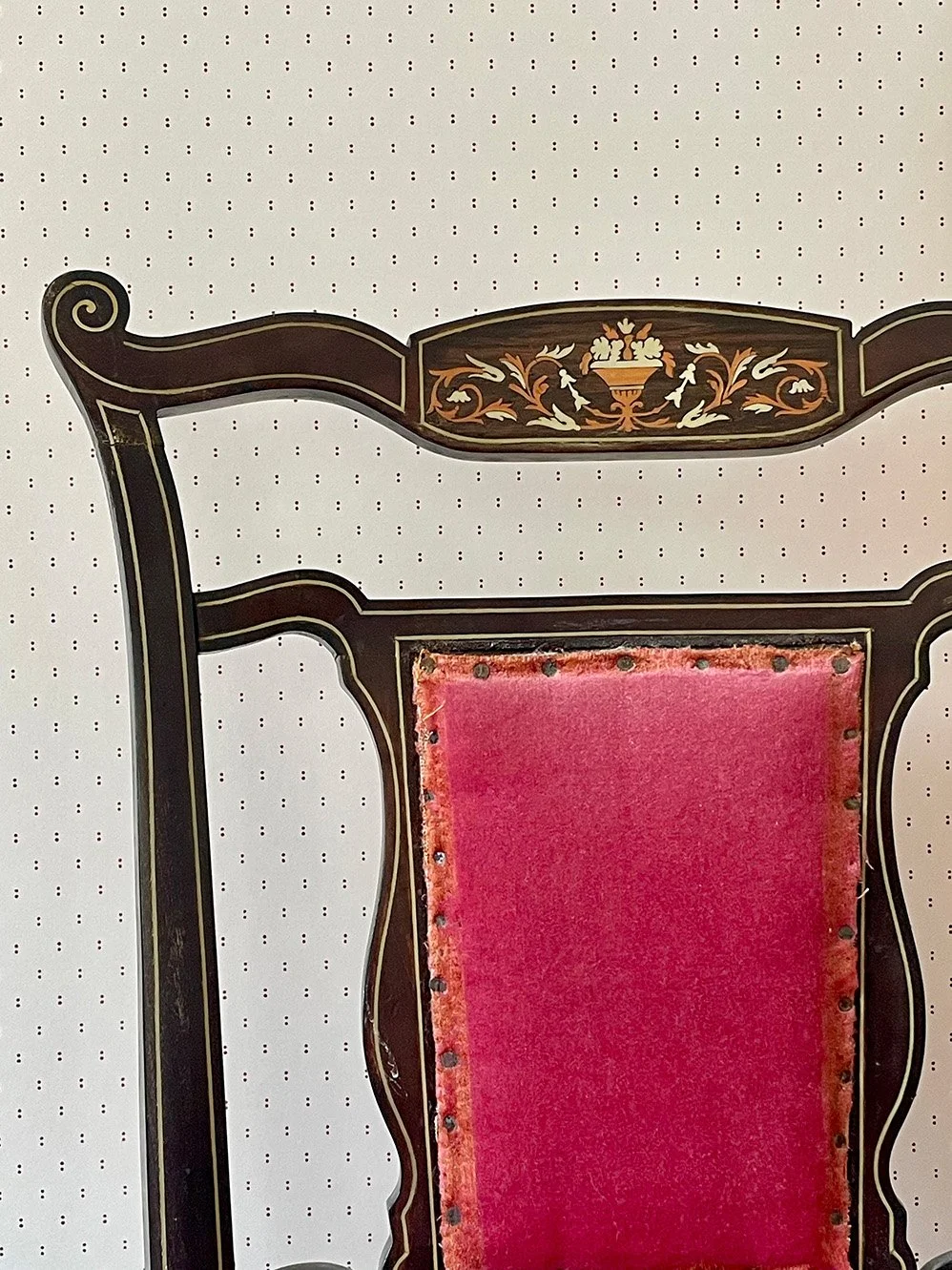 Pair of Dots wallpaper in Plum on cream behind an antique chair with inlay features.