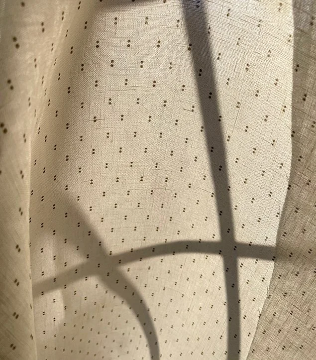 Khaki on cream Petite Pair of Dots fabric framing a window for gentle privacy