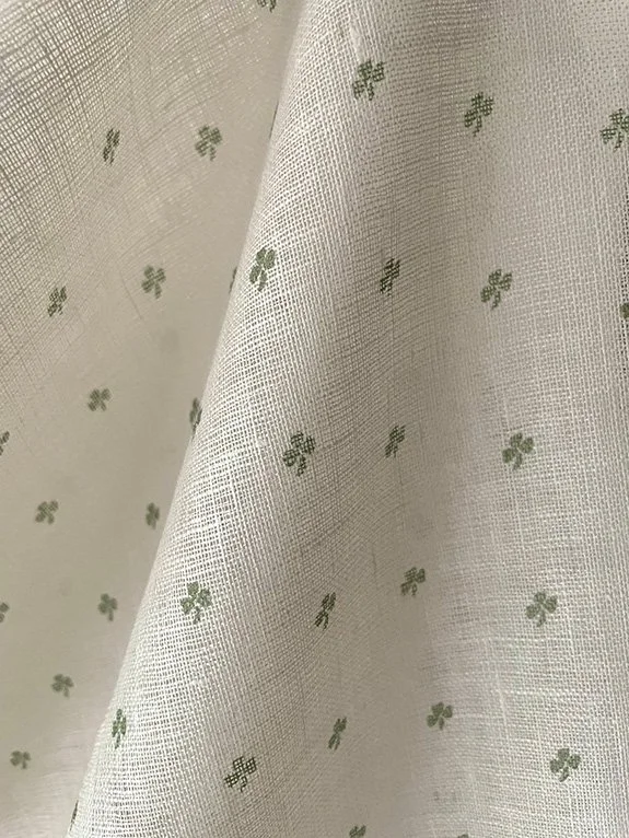 Close-up of Cottage Clover sheer linen in Lichen green, showing pattern and texture.