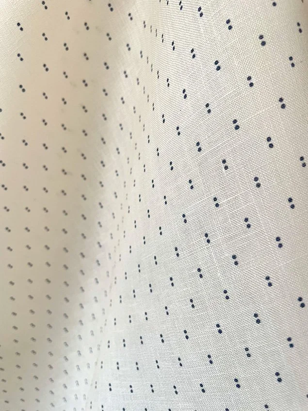 Close view of Petite Pair of Dots ironstone blue on cream, showing fine dot repeat and grain.