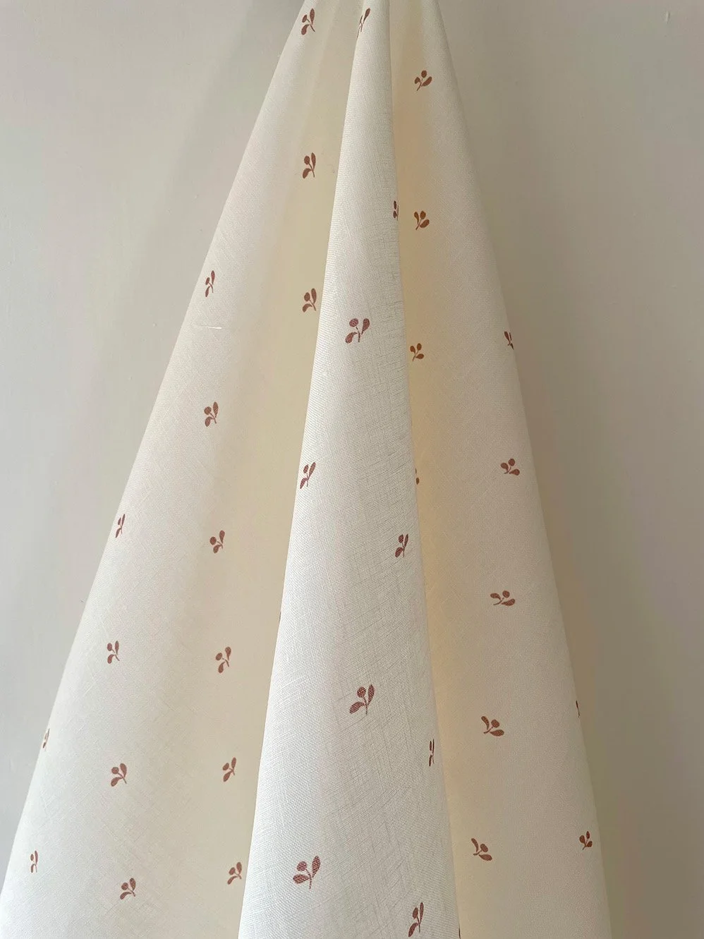 Lawn Flower marsala pink floral fabric hanging in gentle folds for soft furnishings and curtains.