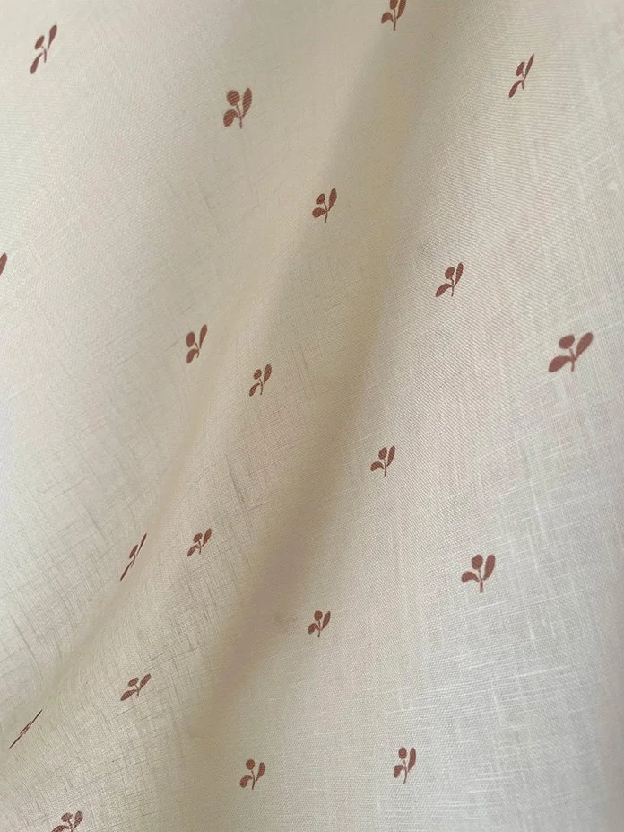 Lawn Flower marsala pink fabric in macro view, revealing small flower motif and weave.