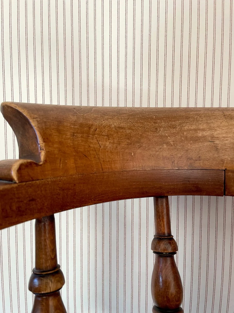 Pillow Stripe Saddle Brown wallpaper sample shown behind antique wooden chair .