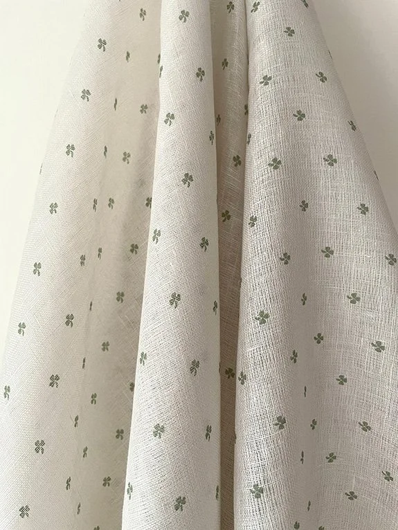 Cottage Clover sheer linen fabric in Lichen Green, draped to showcase softness and natural flow.