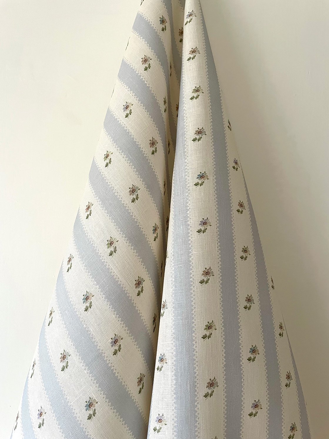 Hat Box Stripe Pale Blue midweight linen hanging length showing overall pale blue candy stripe and daisy sprig pattern.
