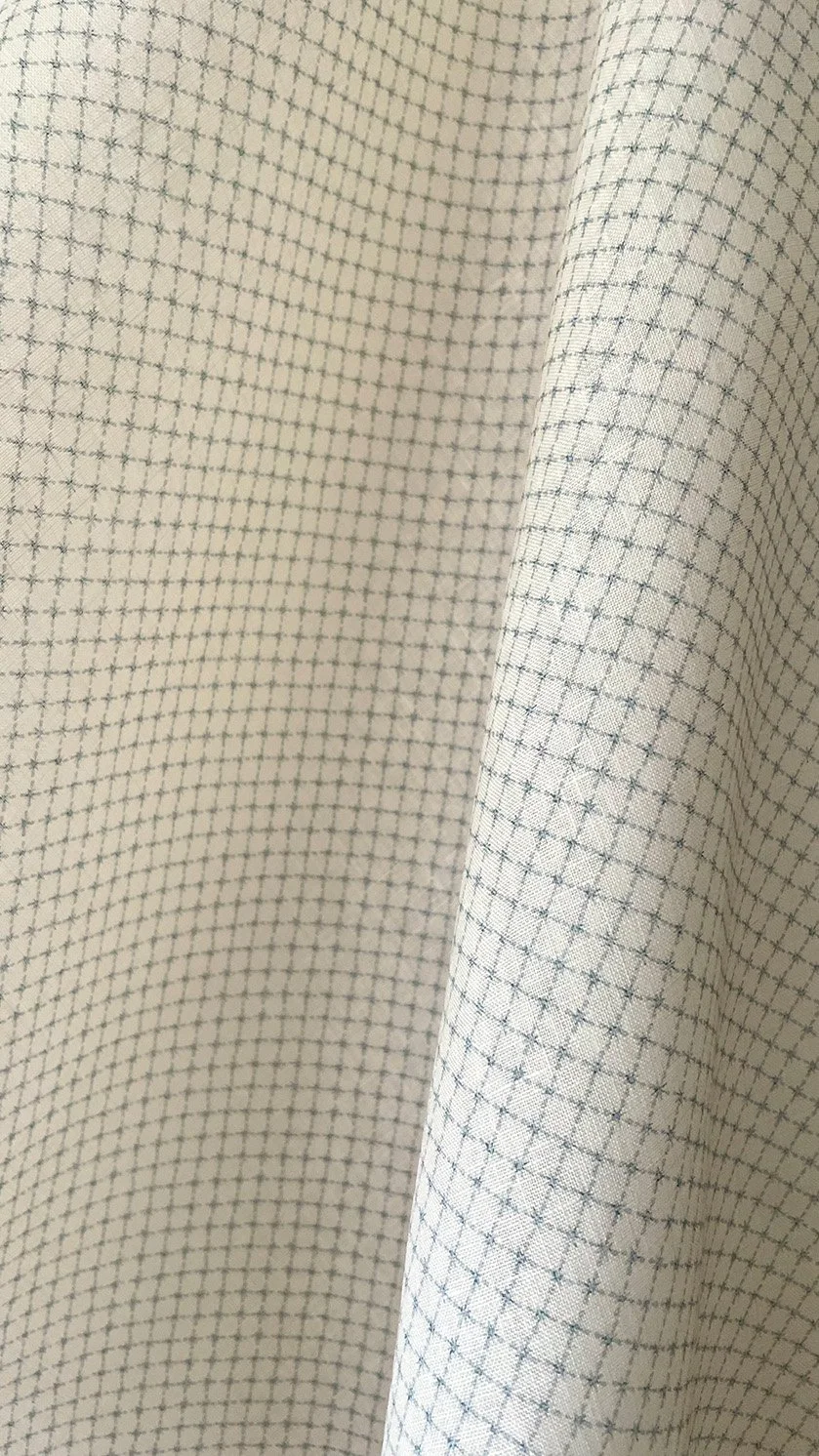 Close-up of Summer Trellis Pale Blue midweight linen showing finely scaled star grid and fabric texture.