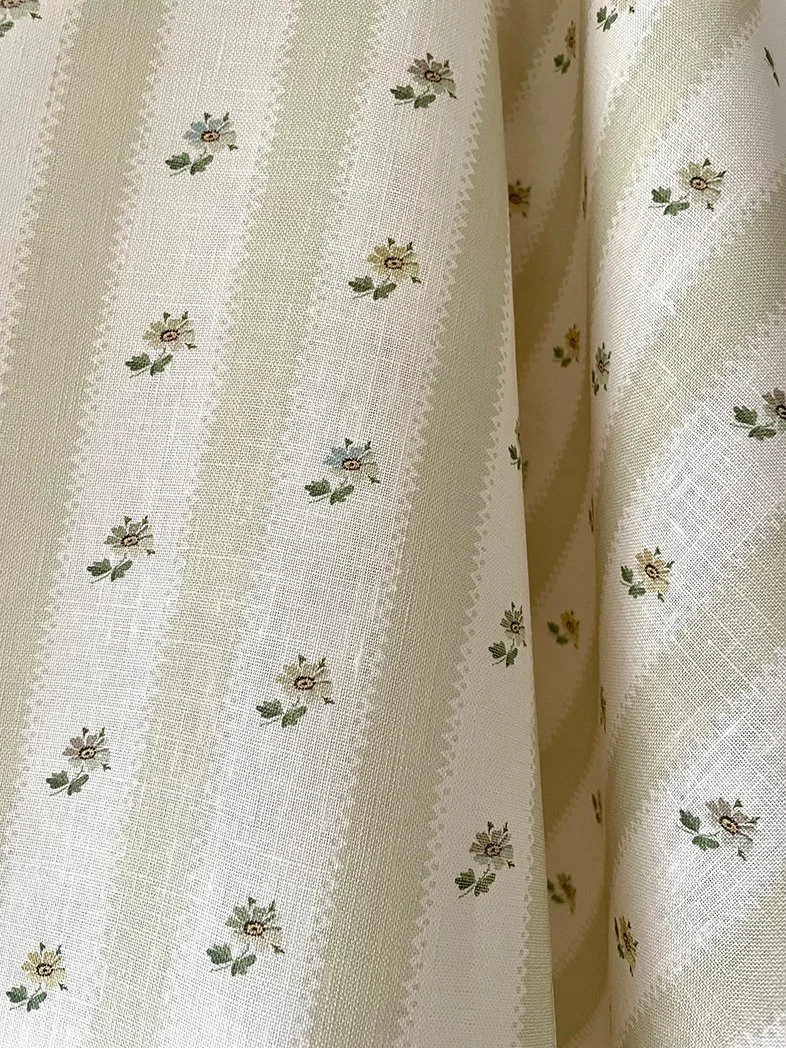 Close-up of Hat Box Stripe Eau de Nile Green midweight linen showing soft green candy stripes and small daisy sprigs.