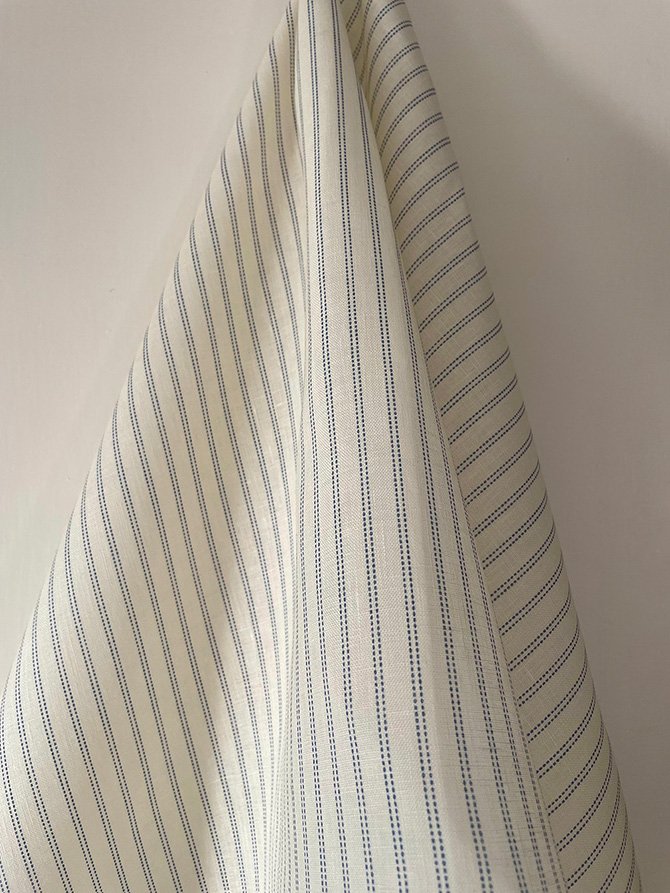 Draped Cornflower Blue Pillow Stripe midweight linen fabric in Cornflower Blue, highlighting texture.