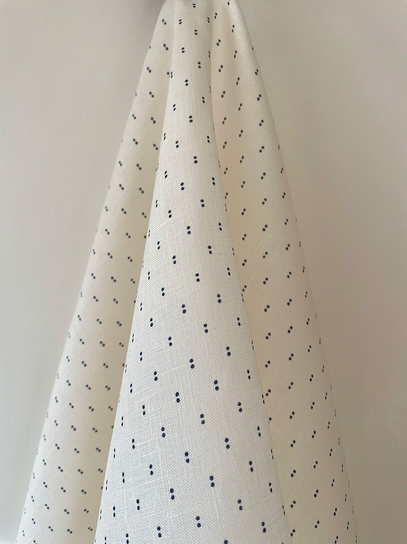 Ironstone blue on cream Petite Pair of Dots fabric length in soft folds, displaying repeat pattern.