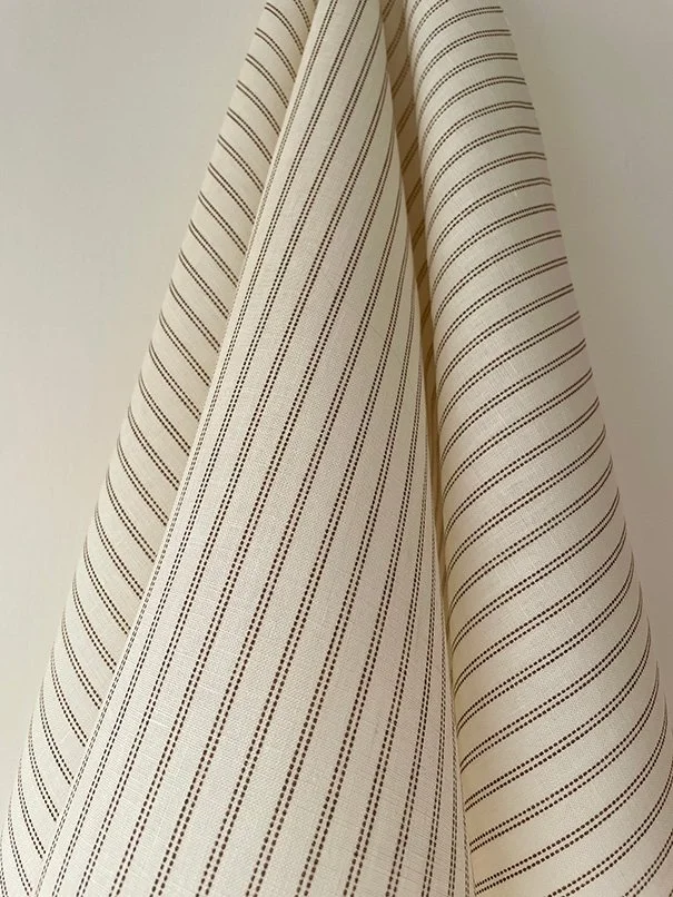 Saddle brown Pillow stripe fabric hanging in relaxed folds to display its drape.