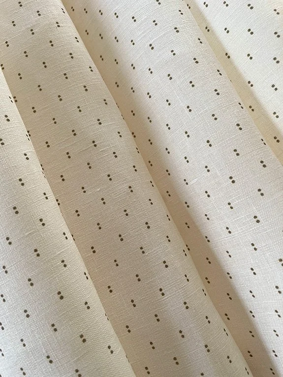 Petite Pair of Dots khaki on cream linen fabric gently folded to show pattern and texture.