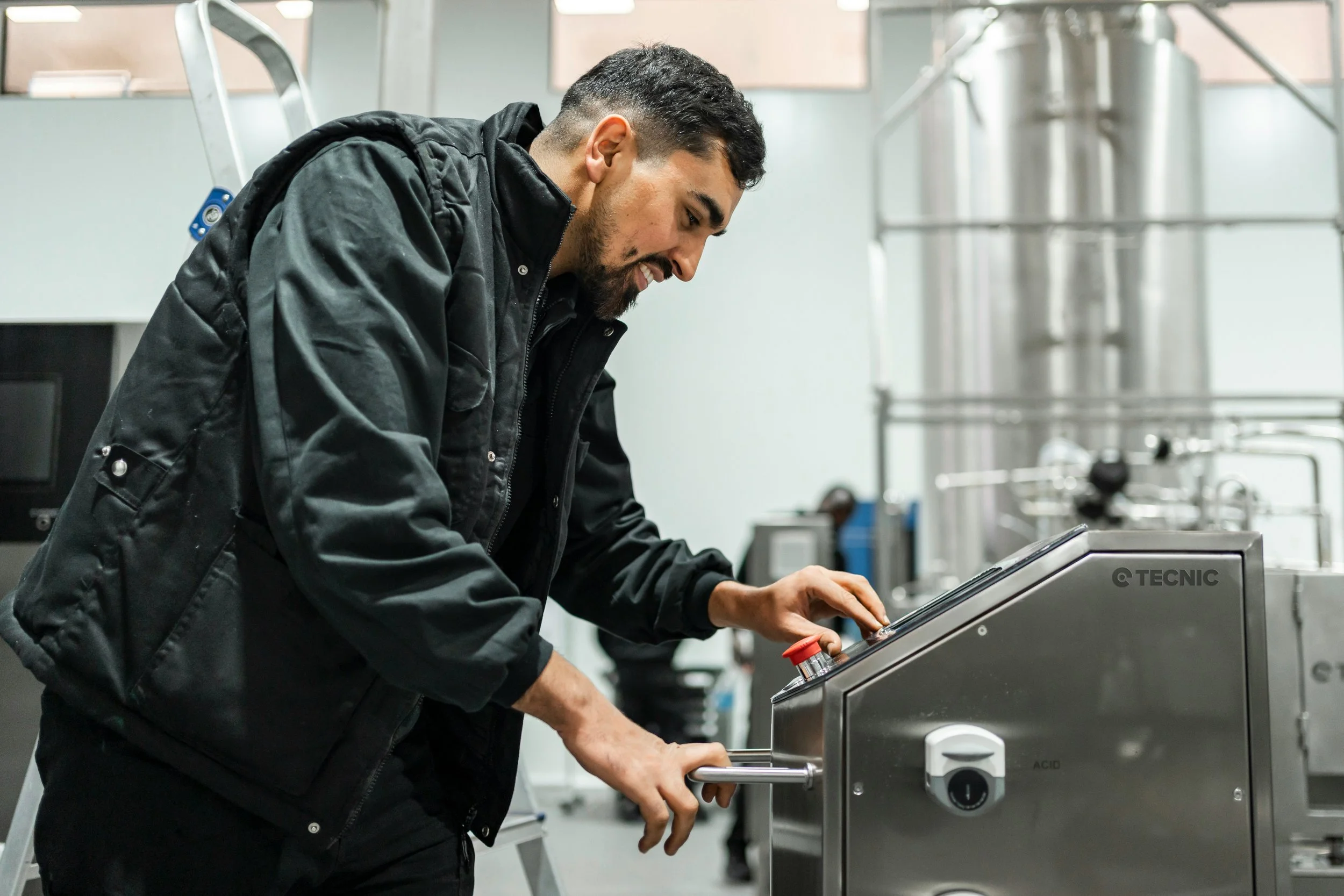 Gloved technician inspecting powder in a clean manufacturing facility