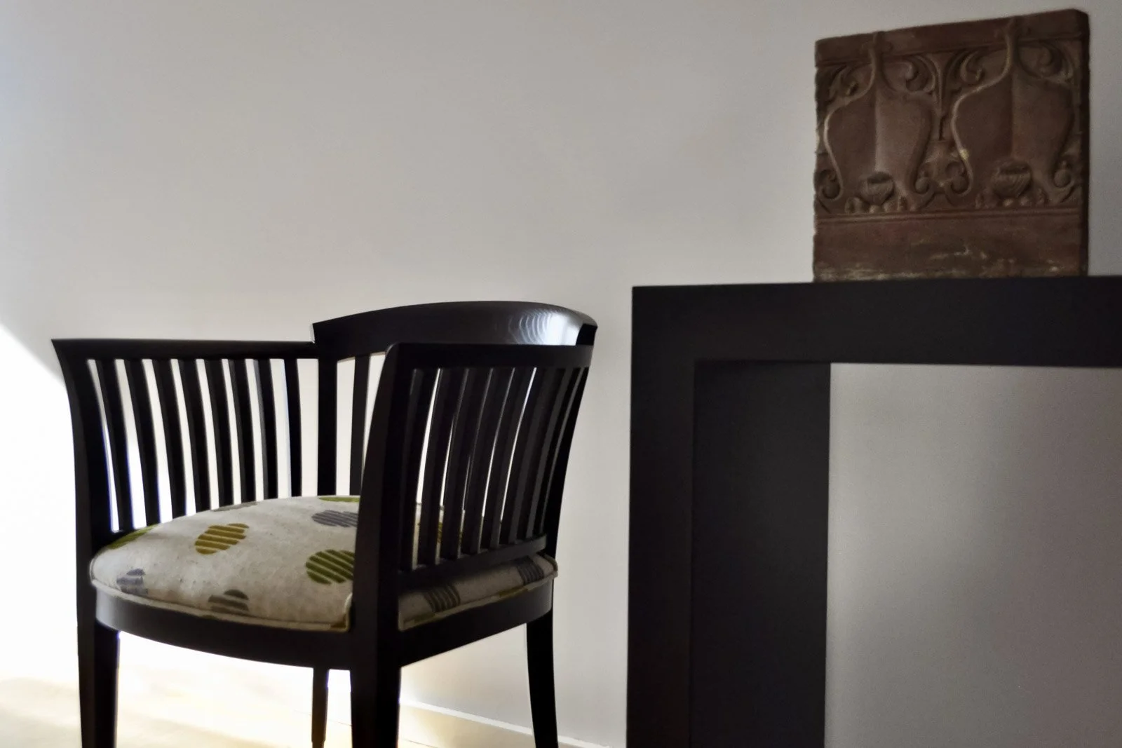 Armchair in chestnut wood with a dark patina, and minimal mahogany console