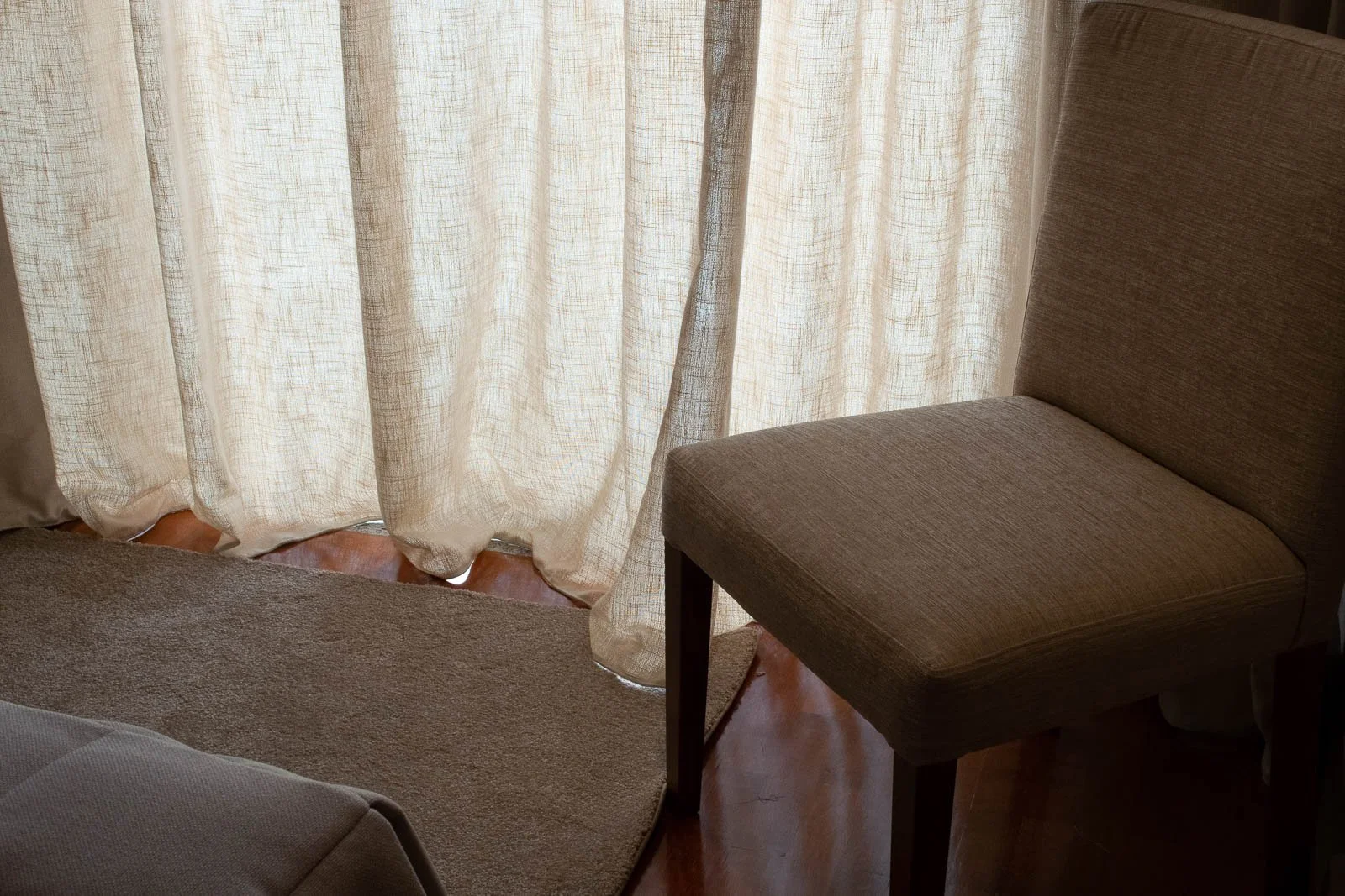 Linen curtains and upholstered chair detail