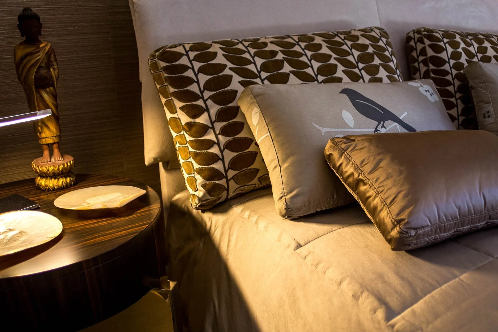 Crème and gold patterned satin upholstery, bedcover, and pillows