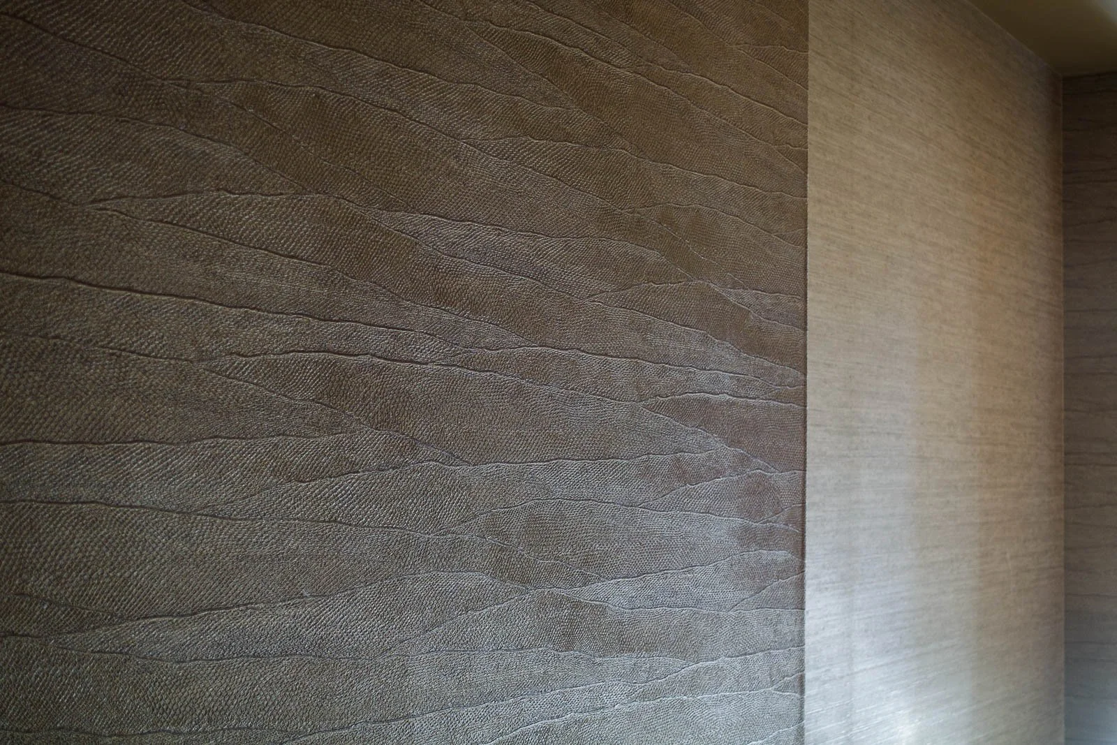 Embossed vinyl and vegetable fiber wallpaper with natural textures on bedroom wall