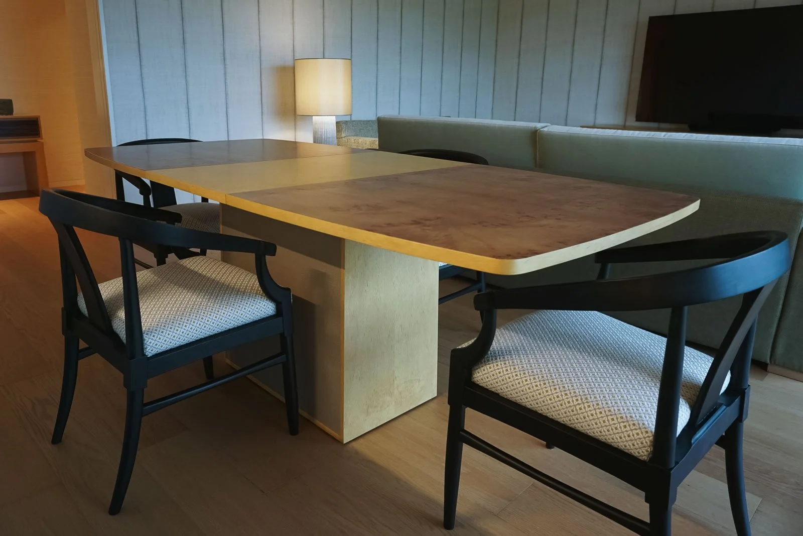 Mesa de jantar extensível em sicómoro e raiz de mirto, com pé em aplicação de pele, e cadeiras de braços em mogno