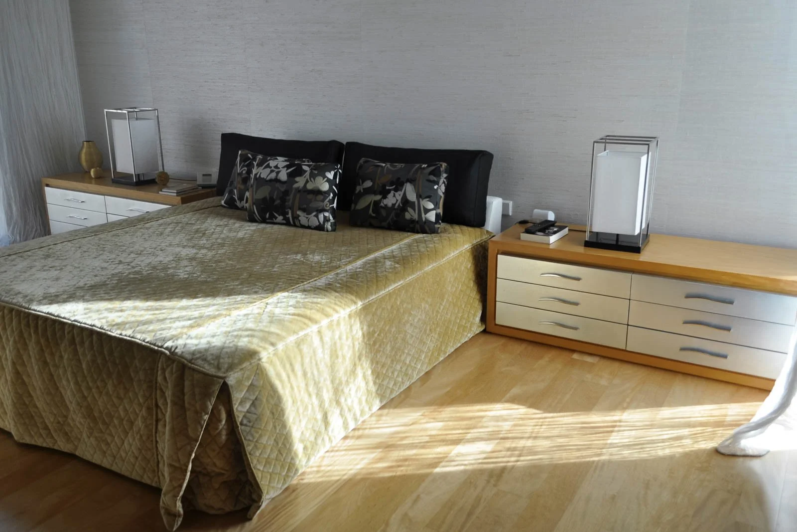 Quarto principal com mobiliário de autor, pavimento em madeira, revestimentos de parede e iluminação selecionada, e têxteis em veludo e cetim
