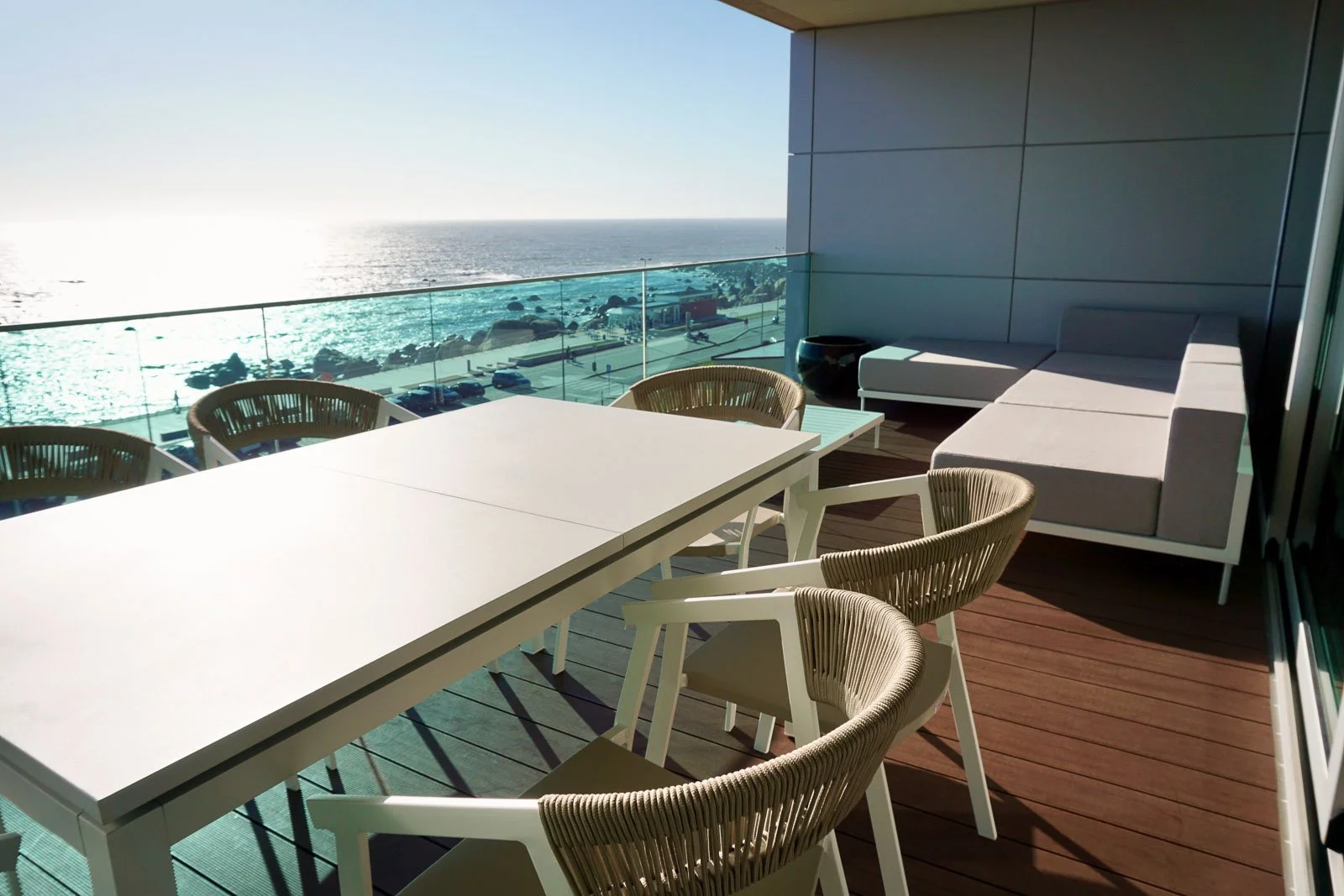 Área de lounge exterior em varanda com vista para o mar