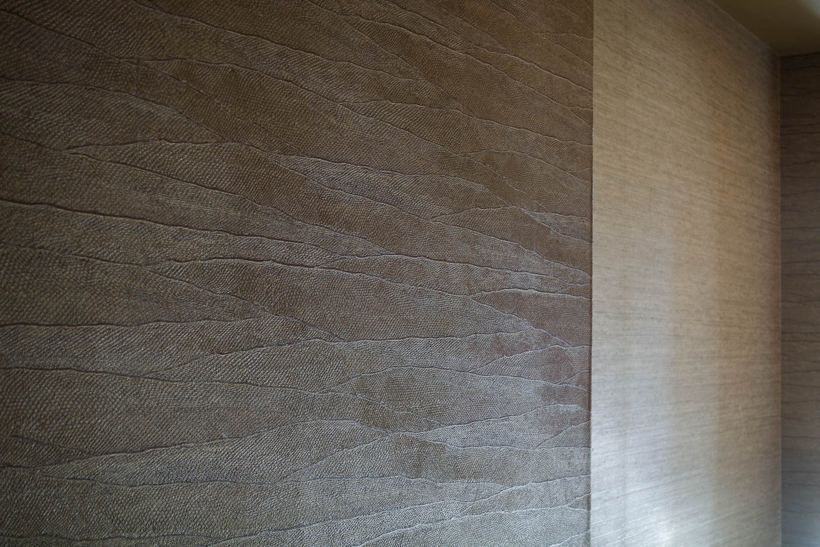 Papel de parede vinílico com relevo e papel de parede de fibras vegetais naturais aplicados em quarto