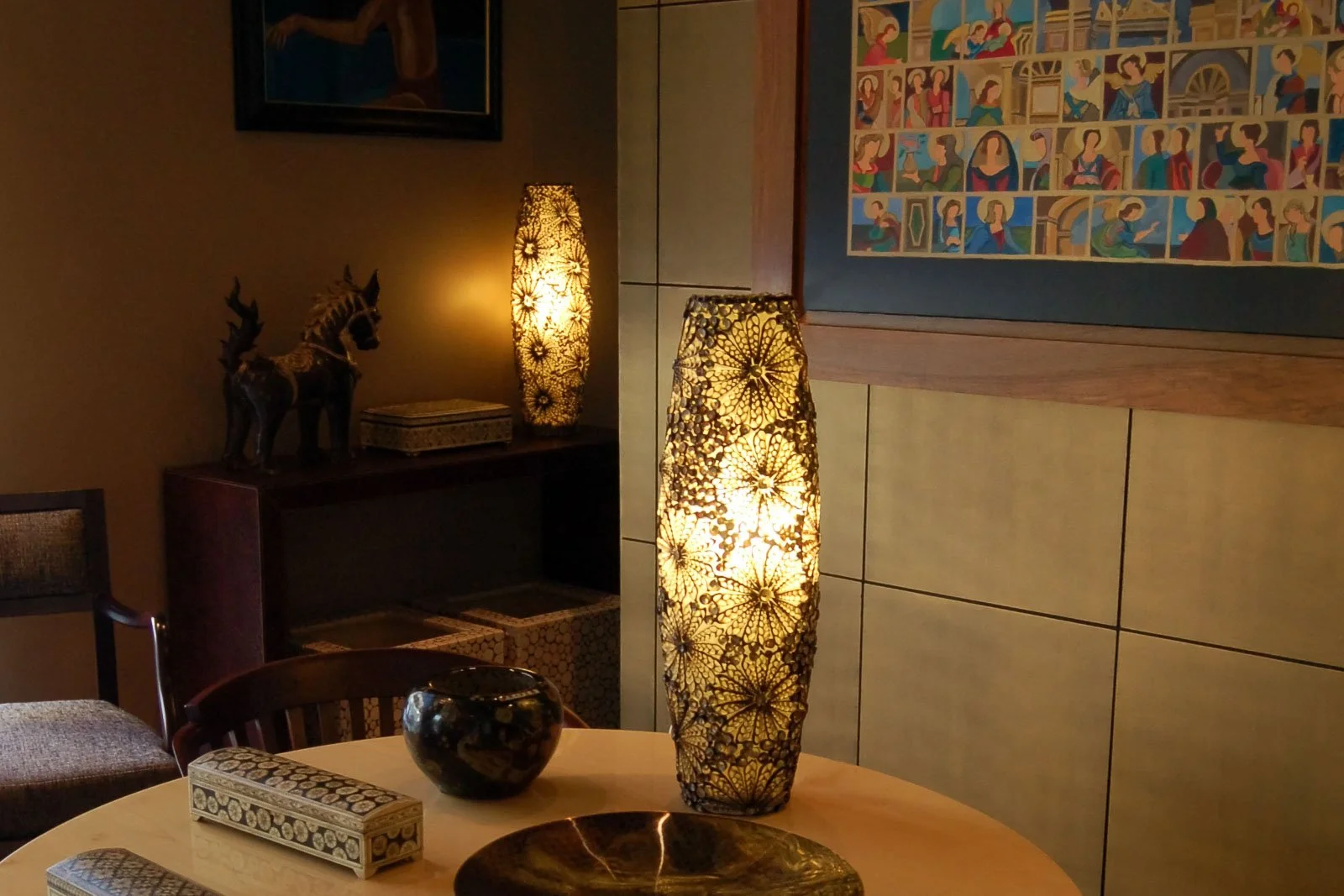 Sala de estar com dois candeeiros de mesa em resina esculpida, com padrões florais elaborados