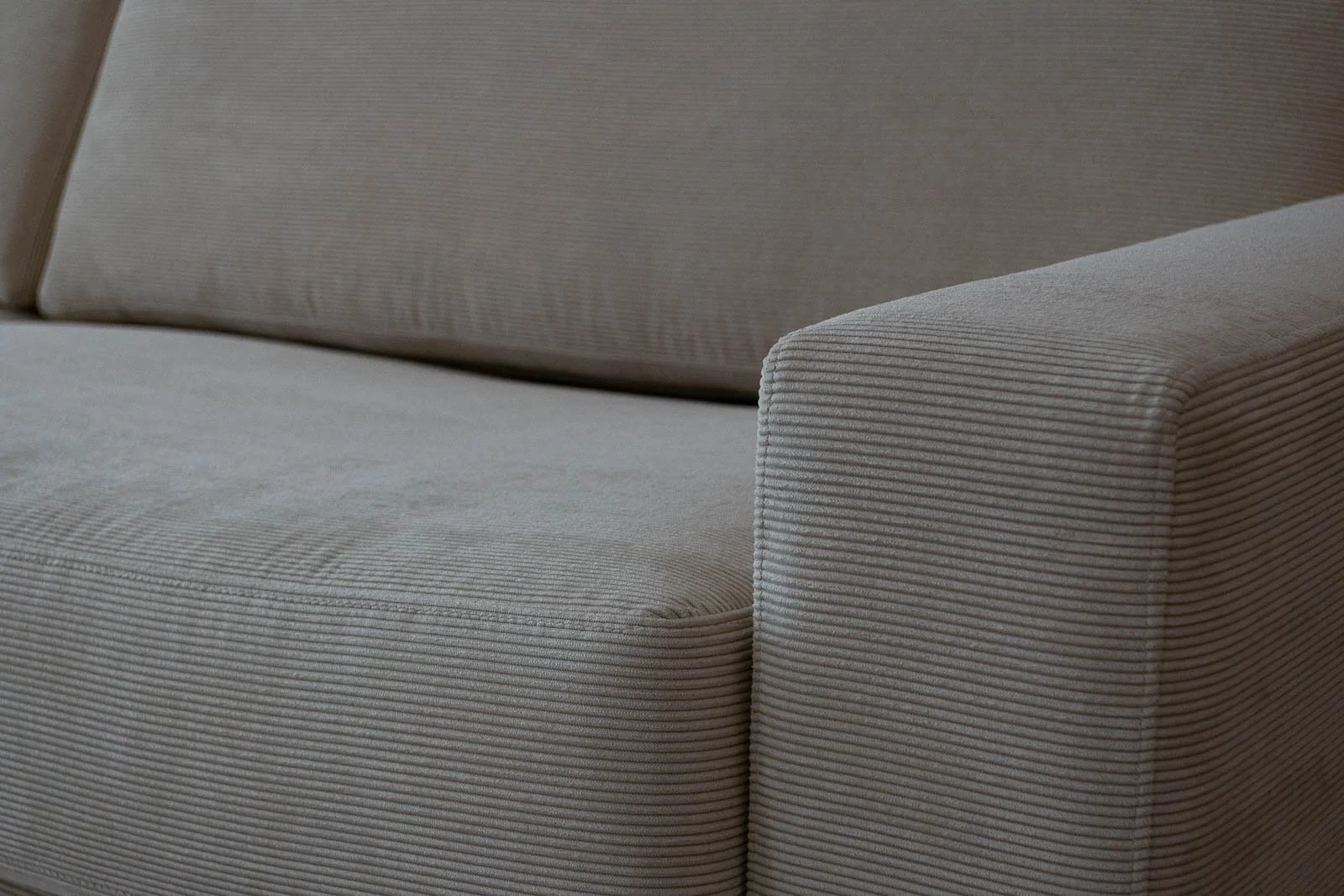 Estofos de sofá branco com textura listrada em relevo, estilo bombasina