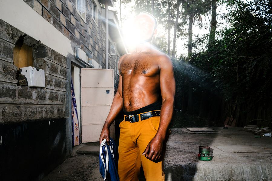 A gay, HIV+ refugee from Uganda poses for a portrait outside his home. He lived in a house with dozens of other LGBT refugees from Uganda just outside of Nairobi. As a refugee, he receives a small stipend each month from the NGO Hias, but it is hard to make ends meet and he often lacks sufficient food for his anti-retrovirals.