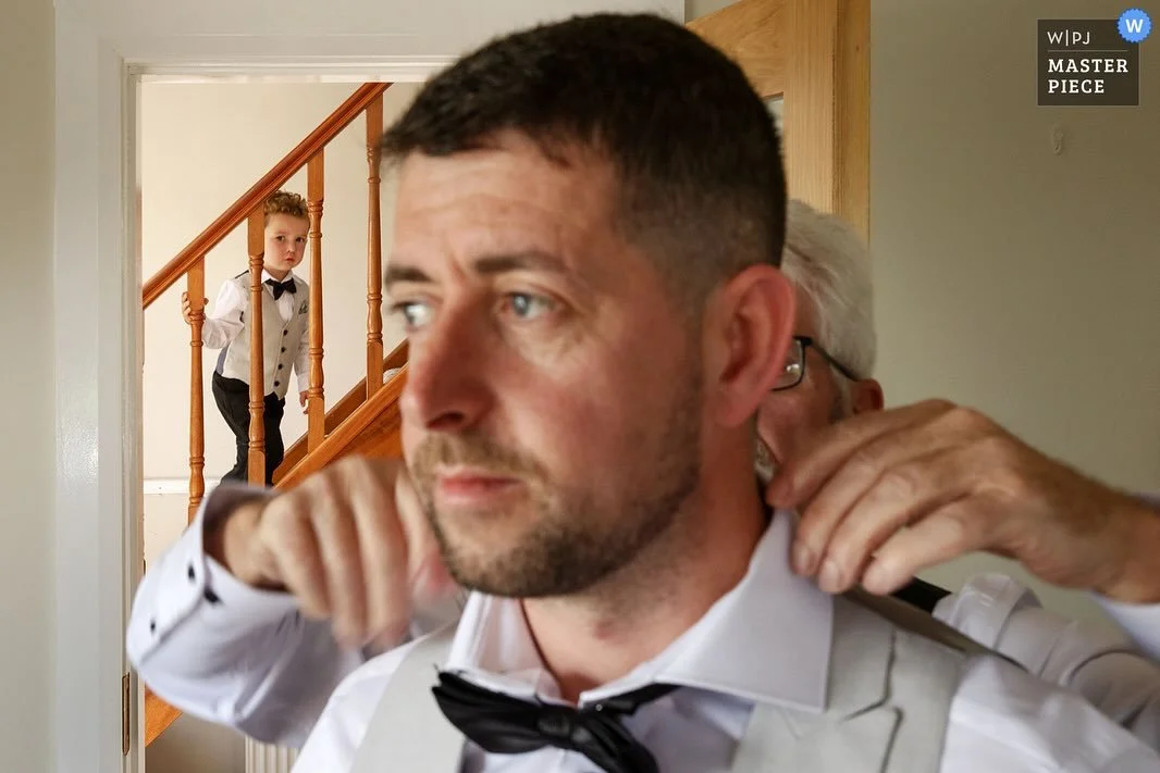 Moya, Derek and their little man Tommy!
The first image is my favourite with little Tommy watching on from a safe distance as his dad is helped by his grandad getting ready, all three generations 🤌 And to top it off it won a @weddingphotojournalists