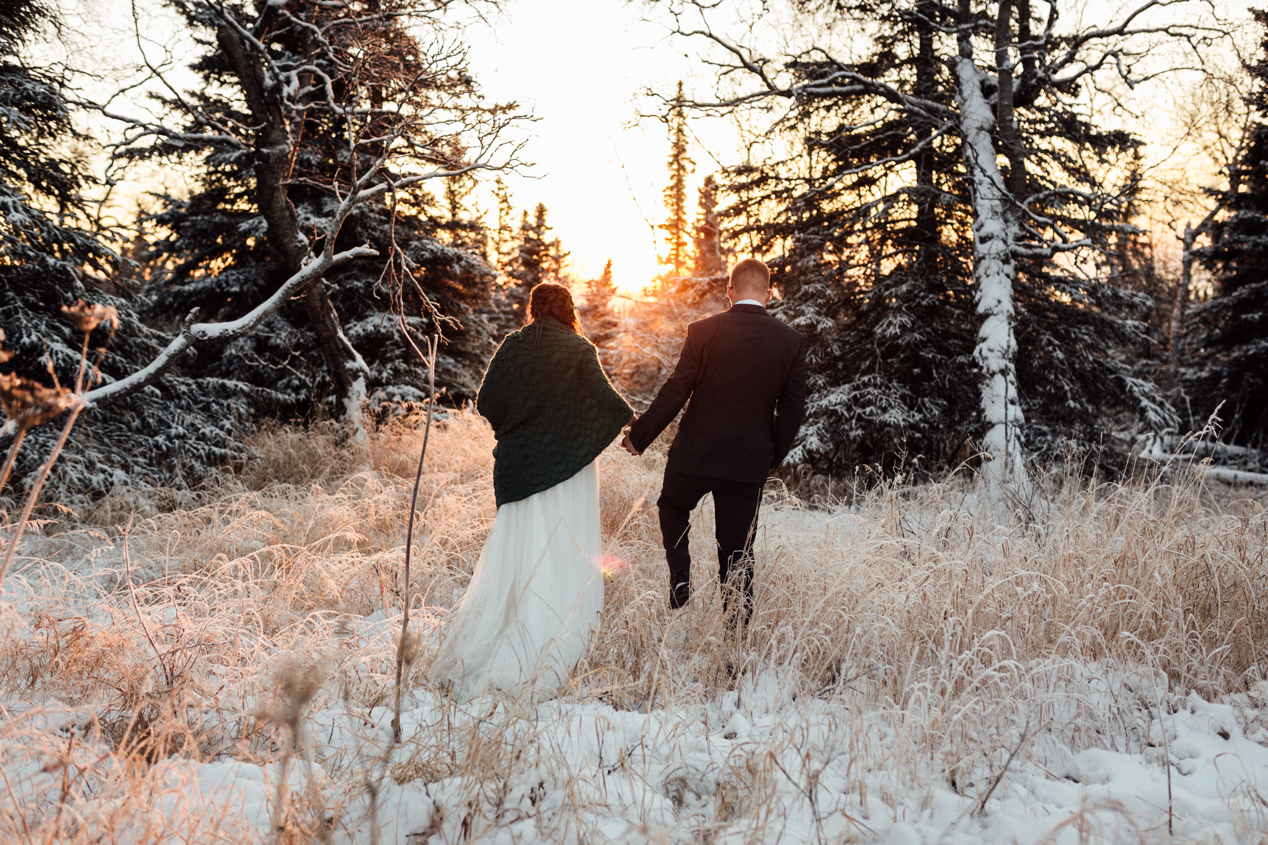 Bride and groom enjoying winter sunset in Alaska