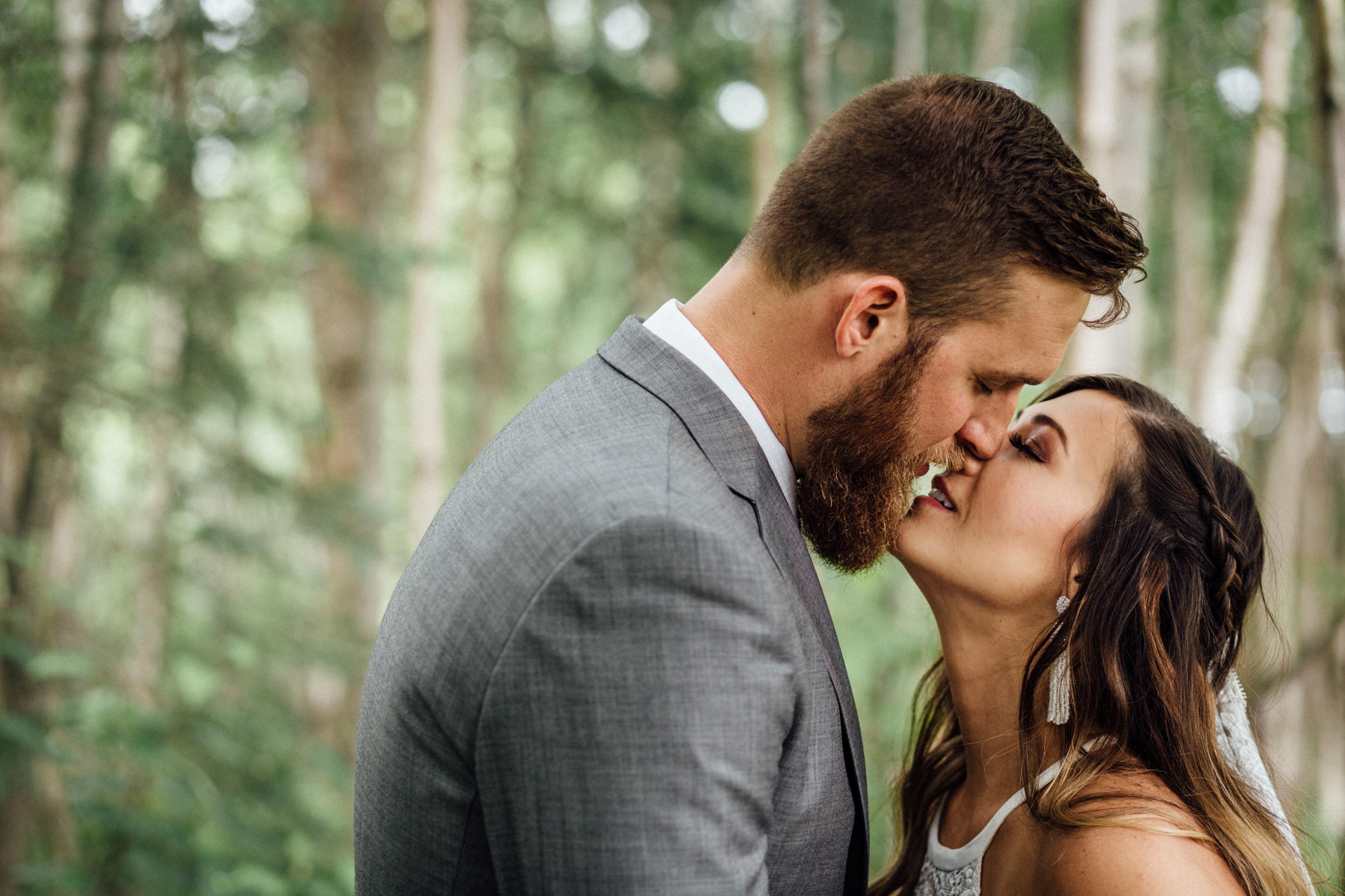 Bride and groom kiss in the forest