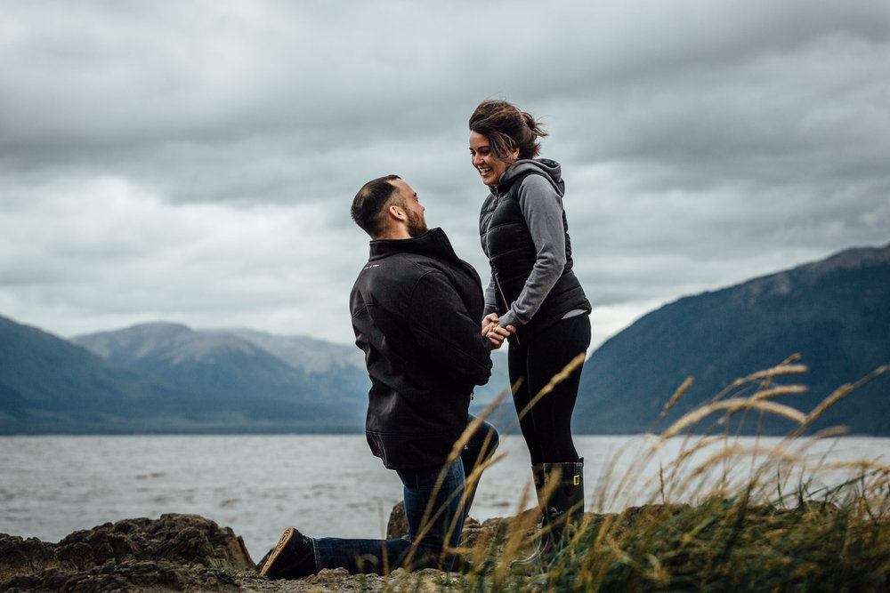 Boyfriend on one knee proposing at Beluga Point in Alaska
