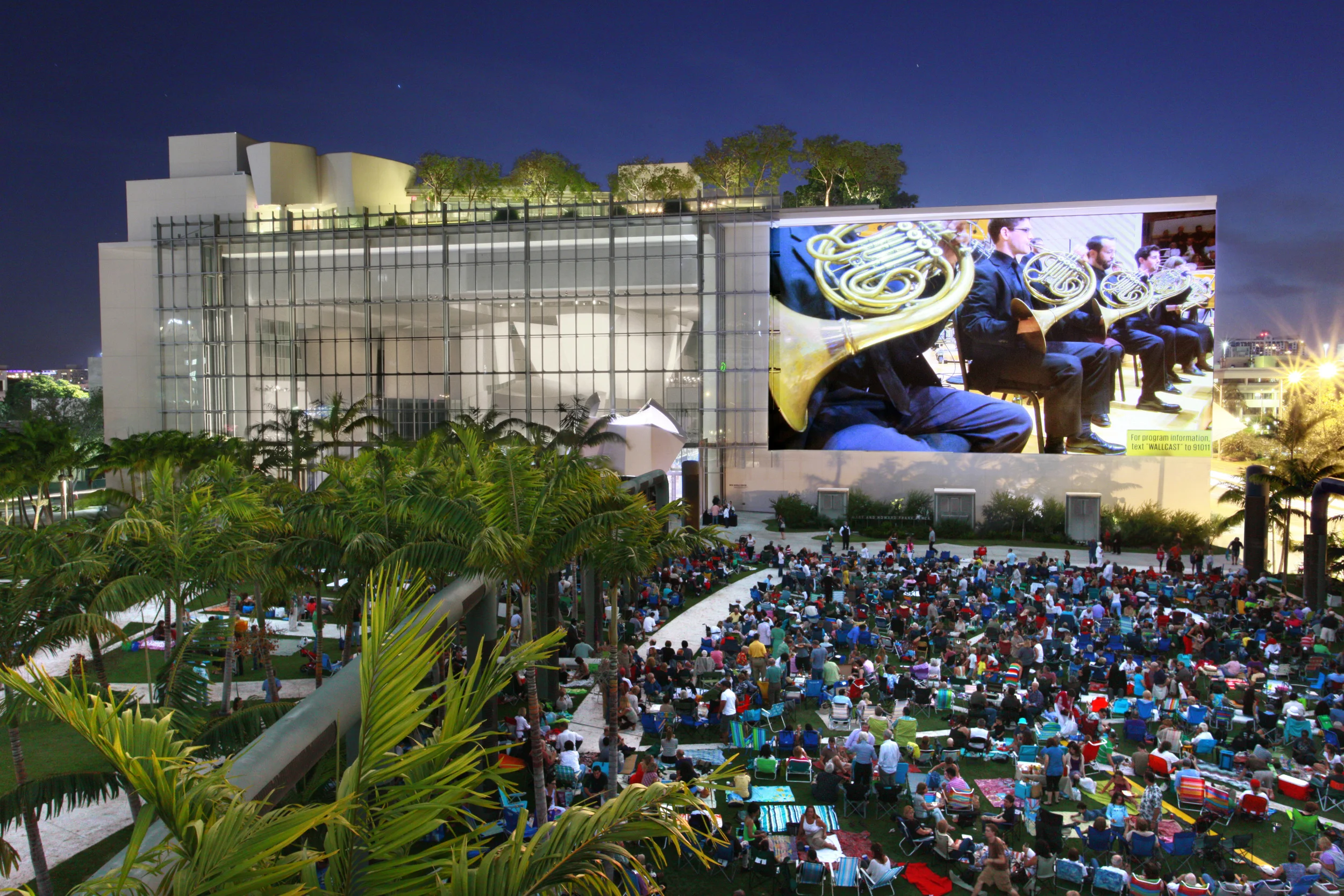 The New World Symphony WALLCAST events are free to the public and allow the community to enjoy select events from the lawns of SoundScape park, on the vast 7000 square foot projection wall, all thanks to a stunning use of high audio and visual technology. (Photo courtesy of New World Center.)