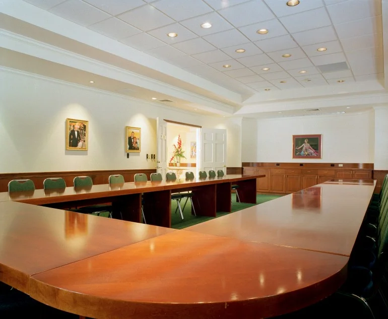 The wood-paneled , board room on the first floor accommodates 50 people comfortably. There is a ceiling recessed slide screen, a built-in buffet, and modular conference tables.