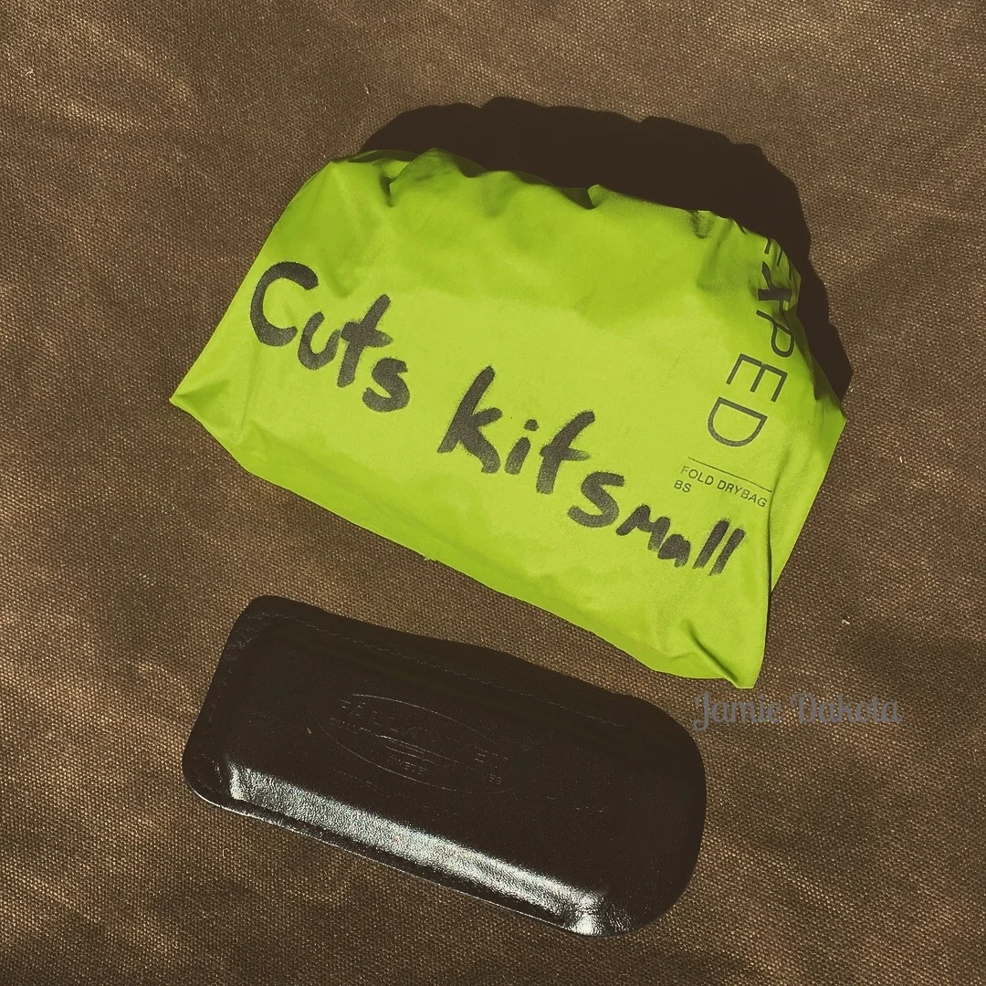 A green bag labeled "Cuts Kit Small" prominently displayed on its surface.