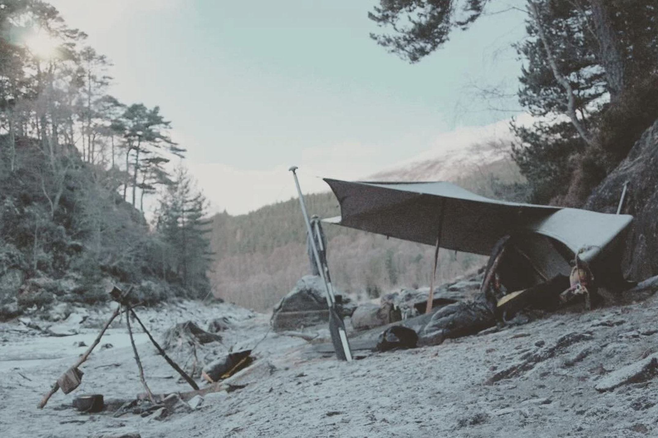 a tarp and canoe shelter near a loch in scotland